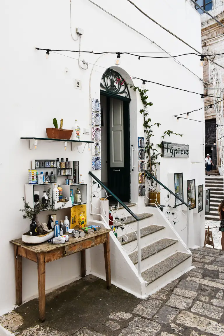 Vicolo bianco con piante nel centro storico di Ostuni